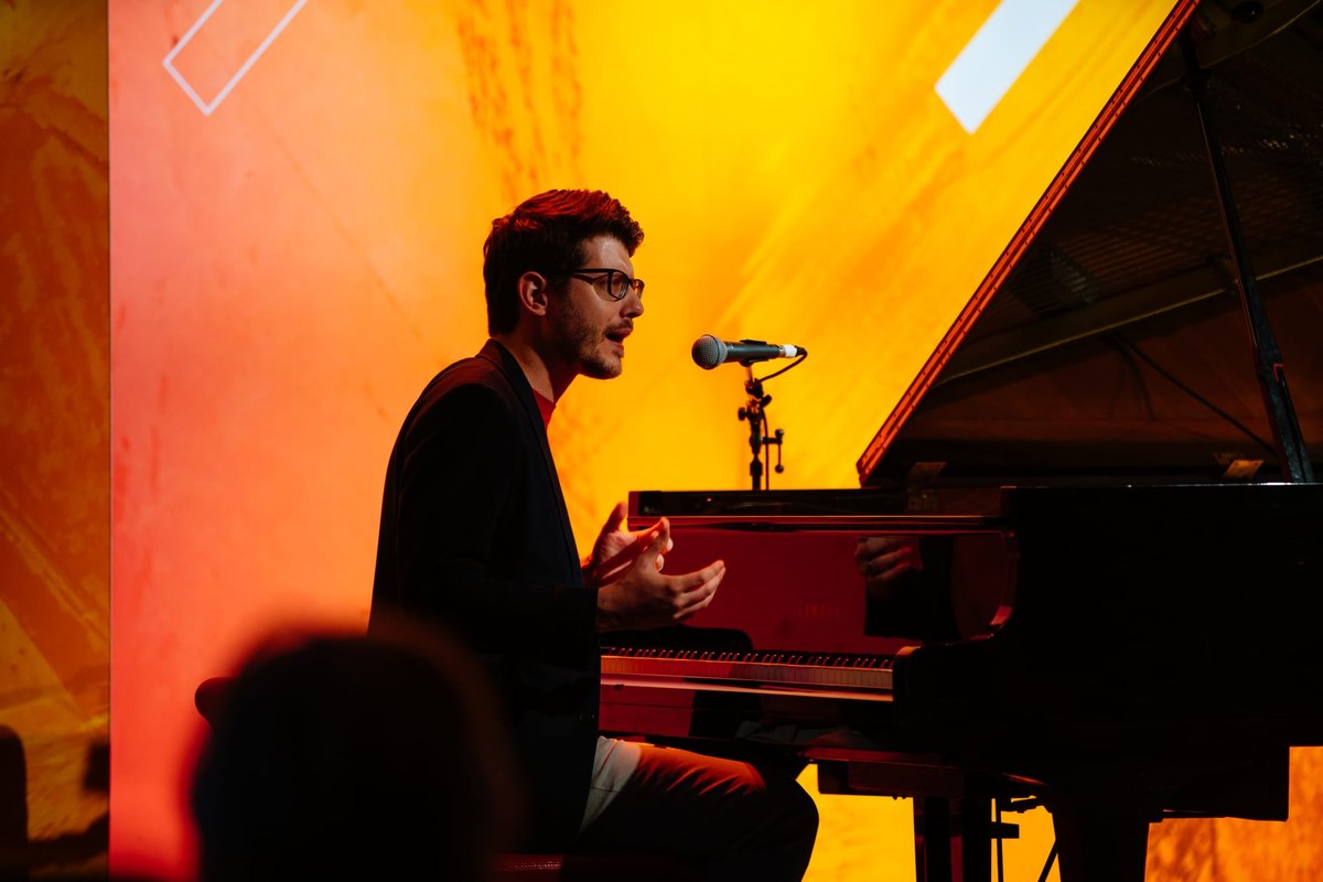 Forrest Brazeal performing at a grand piano on stage